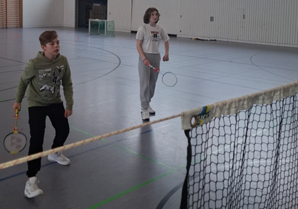 Zwei junge Spieler im vollen Einsatz auf dem Badmintonfeld